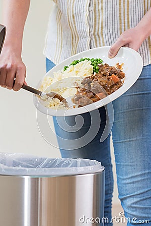 Woman Scraping Food Leftovers Into Garbage Bin Stock Photo