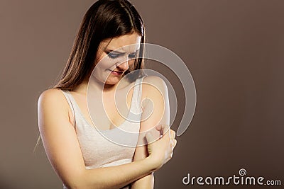 Woman scratching her arm Stock Photo