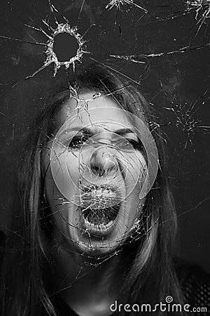 Woman screaming through broken glass. Black and white Stock Photo