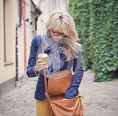 Woman searching for stuff in her handbag. Stock Photo