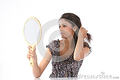 Woman seeing her hairstyle in makeup mirror Stock Photo