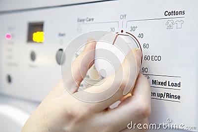 Woman Selecting Cooler Temperature On Washing Machine To Save En Stock Photo