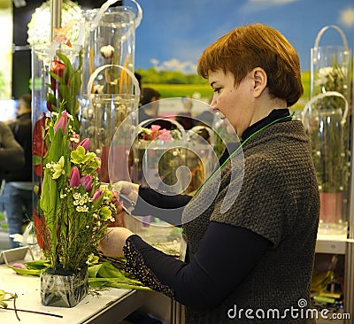 Woman seller arranging bouquet of flowers at the counter of the flower shop. Kyiv, Ukraine Editorial Stock Photo