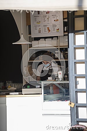 Woman selling ice cream with medical mask at the shop checkout Editorial Stock Photo