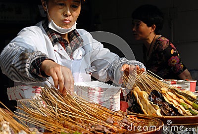 A woman selling local Sichuan street food on Jinli Street, Chengdu Editorial Stock Photo