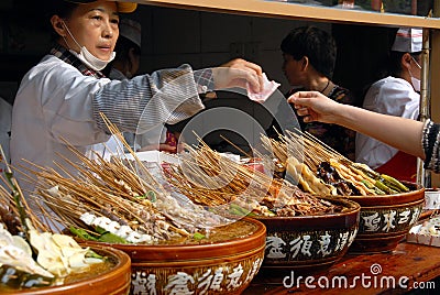 A woman selling local Sichuan street food on Jinli Street, Chengdu Editorial Stock Photo