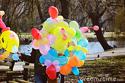 Woman sells colorful balloons in the park. tinted image Stock Photo