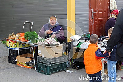 Woman sells vegetables at the Kalvariju market in the Old town of Vilnius, Lithuania Editorial Stock Photo
