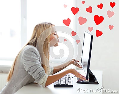 Woman sending kisses with computer monitor Stock Photo