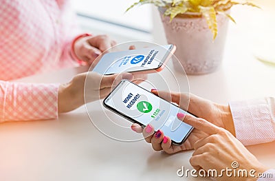 Woman sending money to her friend using mobile phone Stock Photo