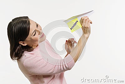 A woman Sends to the sky an abstract plane signed by the word Poverty. Stock Photo