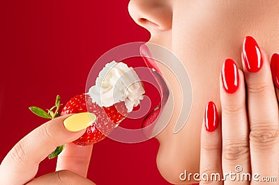 Woman with sensual lips eats strawberries with cream Stock Photo