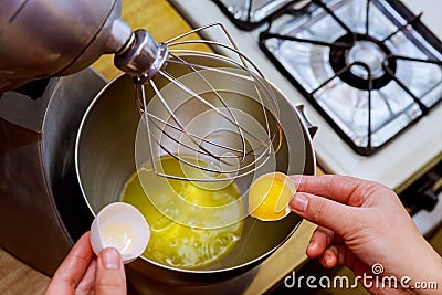 A woman separates egg white from yolk to make a sponge cake Stock Photo