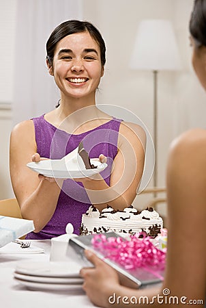 Woman serving birthday cake at party Stock Photo