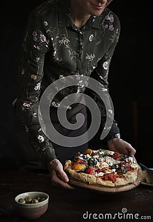 Woman serving homemade pizza on the table Stock Photo
