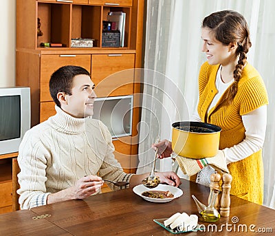 Woman serving soup at table Stock Photo