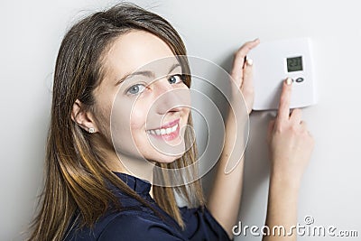 Woman set the thermostat at home Stock Photo