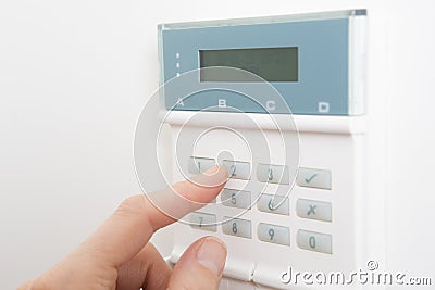 Woman Setting Control Panel On Home Security System Stock Photo