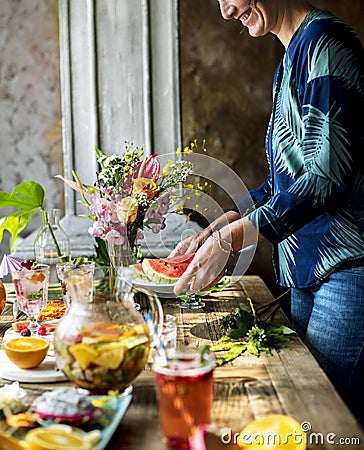 Woman setting fruits and drinks table for party Stock Photo