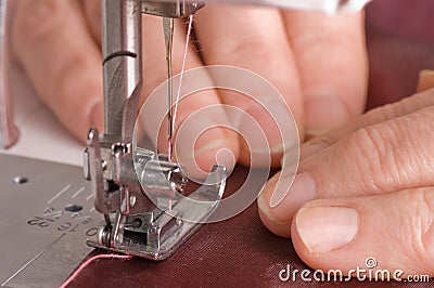 Woman sews on the sewing machine Stock Photo