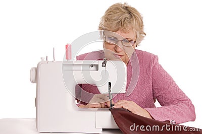 Woman sews on the sewing machine Stock Photo