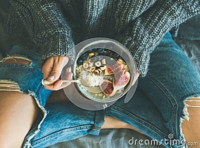 Woman in shabby jeans and sweater eating healthy breakfast Stock Photo