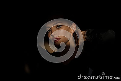 Woman in shadow. Female model with shadows on face looking seductive and sensual on dramatic black studio with light Stock Photo