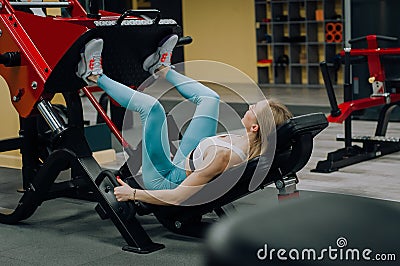 Woman shakes her legs over the bar. Fitness girl shakes leg muscles Stock Photo