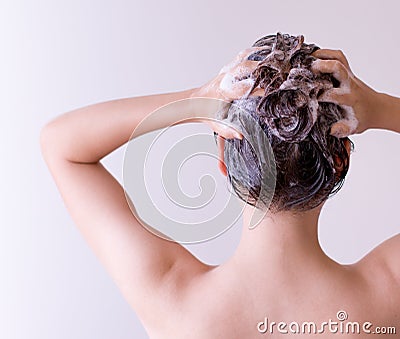 Woman shampoos hair close up with both hands on a white background Stock Photo