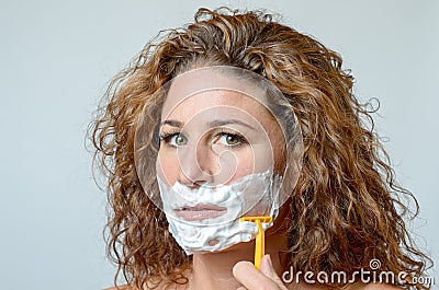 Woman shaving her beard Stock Photo