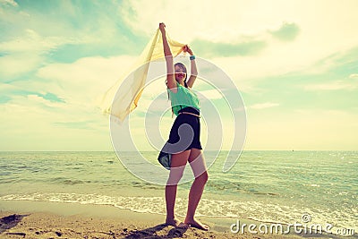 Woman with shawl running on beach Stock Photo