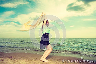 Woman with shawl running on beach Stock Photo