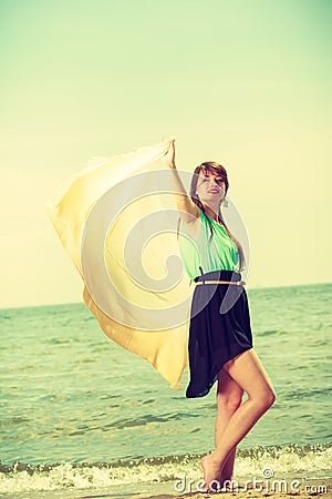 Woman with shawl running on beach Stock Photo