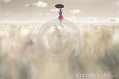 Woman shelters from the sun with her umbrella in a surreal place Stock Photo