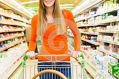 Woman with shopping cart in supermarket Stock Photo