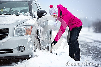 Woman shoveling snow from her car Stock Photo