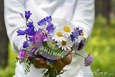 Woman show a natural floreal bouquet with different flowers and colors - concet of nature and environment - people and daisies Stock Photo