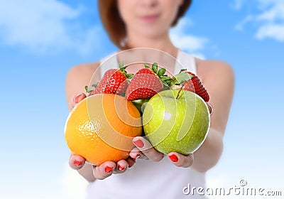 Woman showing apple, orange fruit and strawberries in hands in diet healthy nutrition concept Stock Photo