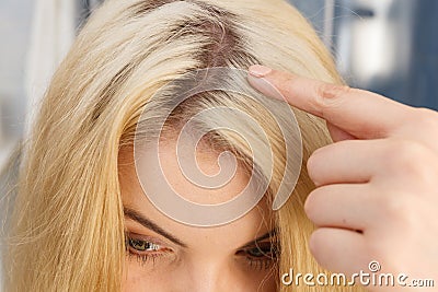 Woman showing blonde hair roots Stock Photo