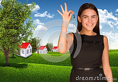 Woman showing key and houses with landscape Stock Photo