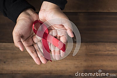 Woman showing red ribbon AIDS ribbon . Stock Photo