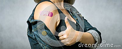 Woman showing shoulder with plaster after getting COVID-19 vaccine Stock Photo