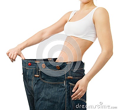 Woman shows her weight loss by wearing an old jeans Stock Photo