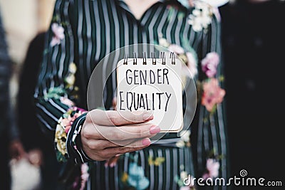 Woman shows notepad with the text gender equality Stock Photo