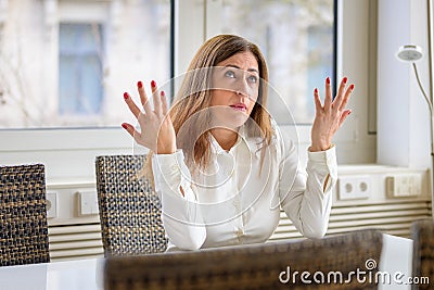 Woman shrugging her shoulders and gesturing with her hands Stock Photo