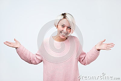 Woman shrugs shoulders as does not know answer, being clueless and uncertain Stock Photo