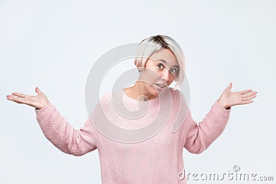 Woman shrugs shoulders as does not know answer, being clueless and uncertain Stock Photo