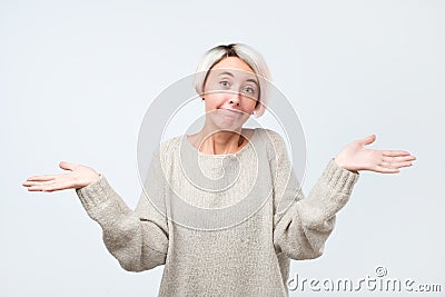 Woman shrugs shoulders as does not know answer, being clueless and uncertain Stock Photo