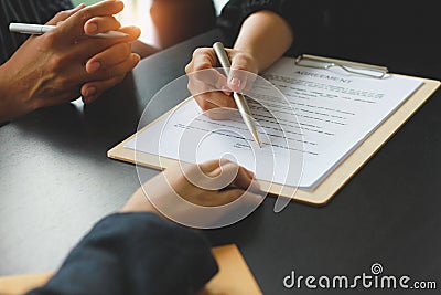 A woman signed a document to become a new employee of the office. Contract and job application concepts Stock Photo