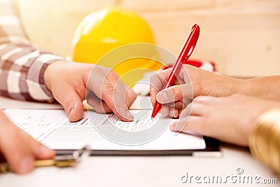 Woman signing construction contract with contractor to build a house Stock Photo